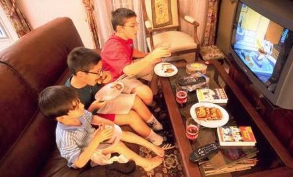 Семья ест перед телевизором